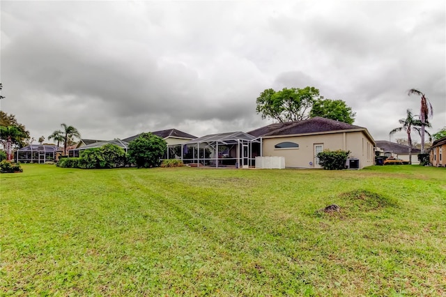 view of yard with a lanai and central AC unit