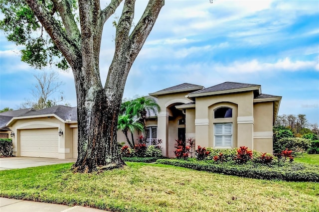 view of front of home with stucco siding, driveway, an attached garage, and a front yard