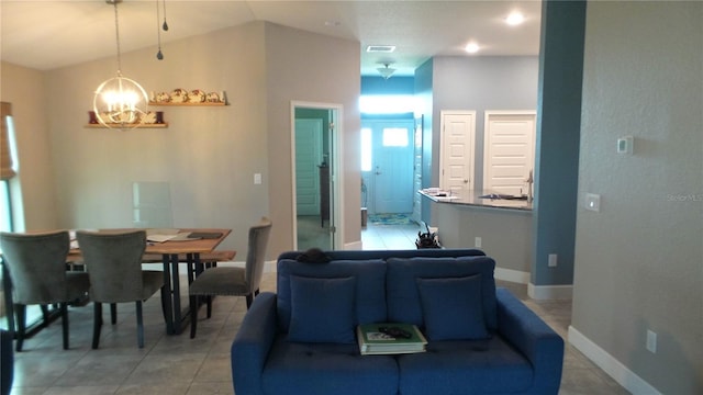 living room with visible vents, baseboards, lofted ceiling, light tile patterned floors, and a notable chandelier