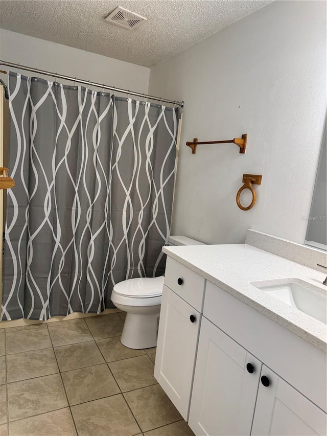 full bathroom with visible vents, toilet, a textured ceiling, tile patterned flooring, and vanity