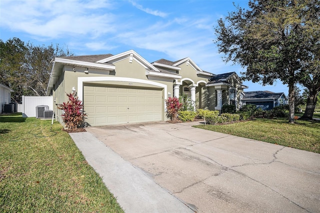 view of front of house with a front lawn, fence, concrete driveway, stucco siding, and an attached garage