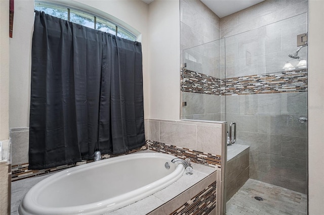 bathroom featuring a bath and a stall shower