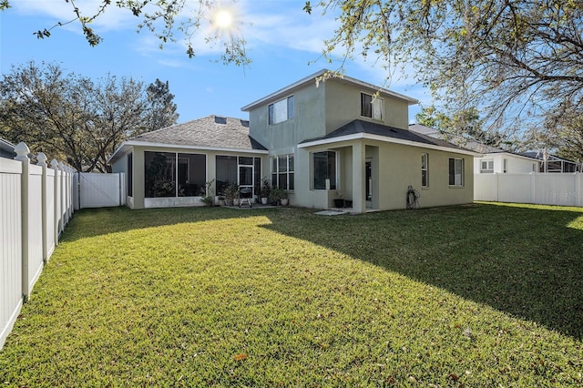 back of property with stucco siding, a lawn, a fenced backyard, and a sunroom