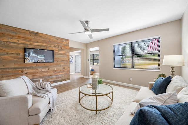 217 Emerald Ln, Largo, FL 33771 - living area with wood walls, an accent wall, a ceiling fan, and wood finished floors