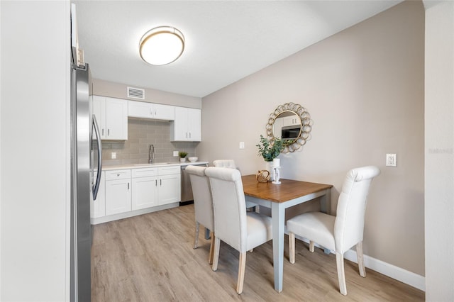 217 Emerald Ln, Largo, FL 33771 - dining space with baseboards, visible vents, and light wood-type flooring