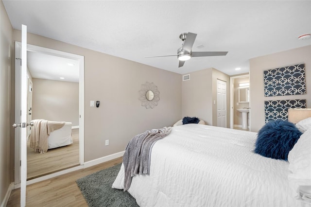 217 Emerald Ln, Largo, FL 33771 - bedroom with ensuite bathroom, visible vents, light wood-style flooring, baseboards, and ceiling fan