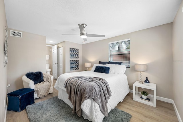 217 Emerald Ln, Largo, FL 33771 - bedroom featuring ensuite bath, baseboards, visible vents, light wood-style floors, and ceiling fan