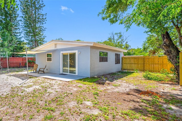 217 Emerald Ln, Largo, FL 33771 - back of house featuring stucco siding, a patio area, and fence private yard