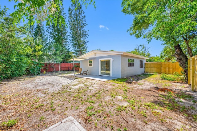 217 Emerald Ln, Largo, FL 33771 - rear view of property featuring a fenced backyard, stucco siding, and a patio area