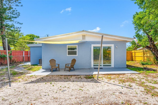 217 Emerald Ln, Largo, FL 33771 - rear view of property featuring fence, stucco siding, and a patio
