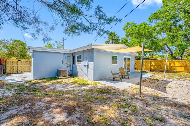 217 Emerald Ln, Largo, FL 33771 - back of house featuring stucco siding, fence, a patio, a gate, and central AC