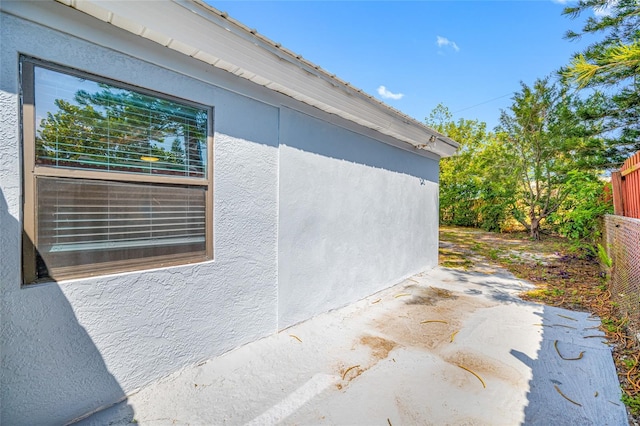 217 Emerald Ln, Largo, FL 33771 - view of side of property featuring stucco siding and fence