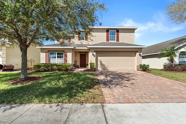 traditional home with stucco siding, an attached garage, decorative driveway, and a front lawn