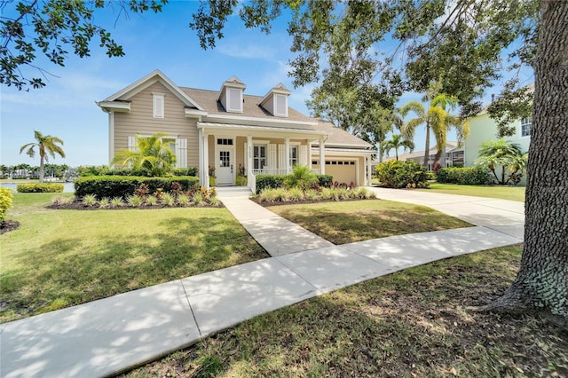 view of front of house featuring an attached garage, a porch, concrete driveway, and a front yard