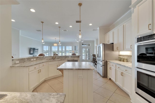 kitchen featuring a sink, appliances with stainless steel finishes, a center island, and ornamental molding