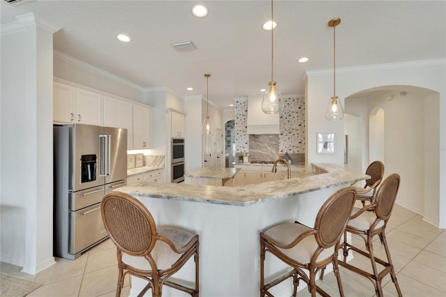 kitchen with backsplash, light tile patterned floors, arched walkways, and appliances with stainless steel finishes