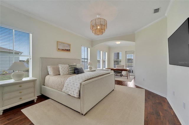 bedroom featuring visible vents, arched walkways, baseboards, and dark wood finished floors