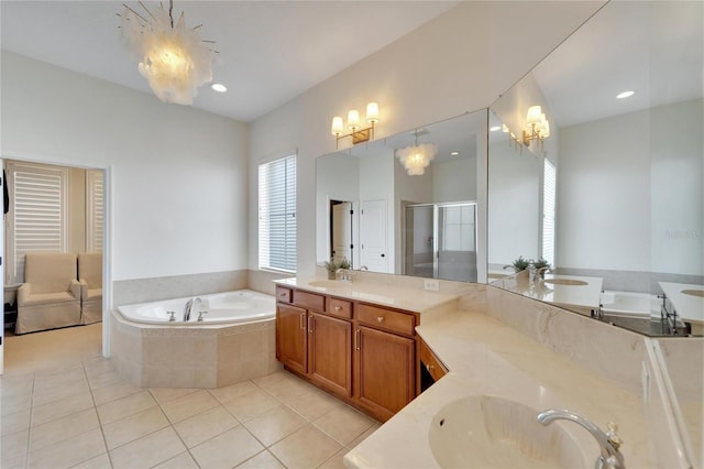 full bathroom with tile patterned flooring, a garden tub, two vanities, a stall shower, and a sink