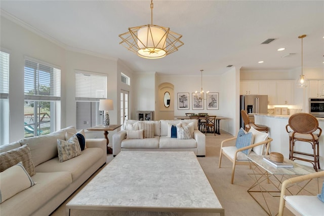 living room with visible vents, light colored carpet, a chandelier, and crown molding