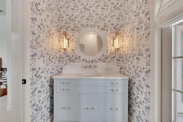 bathroom with wallpapered walls and vanity