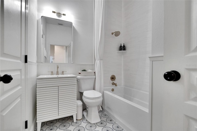 bathroom with shower / bath combo with shower curtain, toilet, tile walls, wainscoting, and vanity