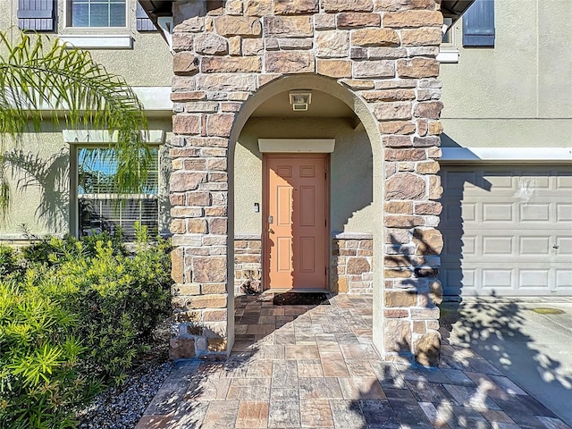 entrance to property featuring stucco siding and stone siding