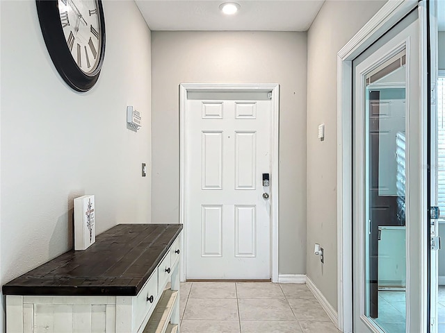 entryway featuring light tile patterned floors and baseboards