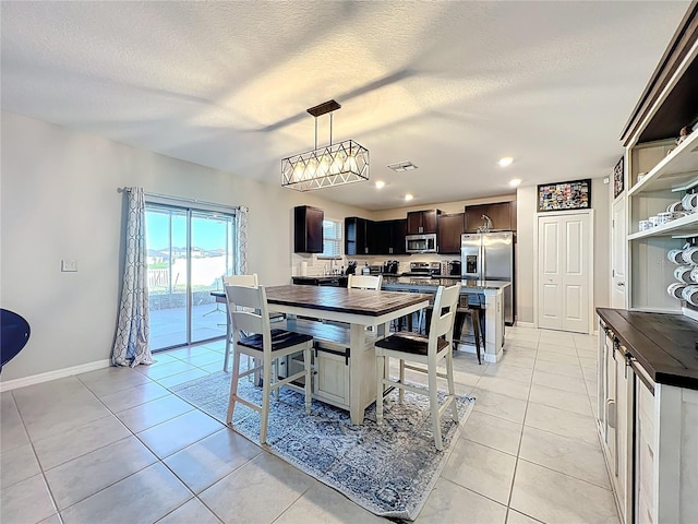 dining room with visible vents, baseboards, light tile patterned floors, recessed lighting, and a textured ceiling