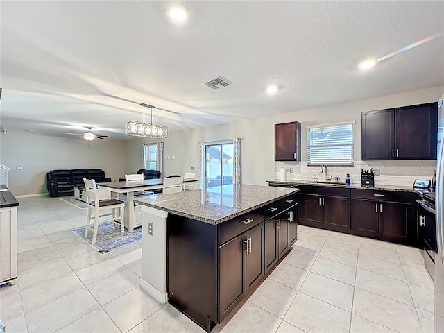 kitchen featuring light tile patterned floors, visible vents, backsplash, and a sink