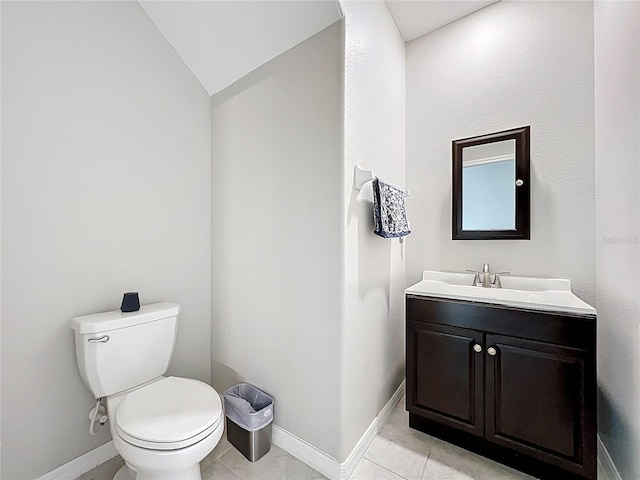 bathroom featuring baseboards, lofted ceiling, toilet, and vanity