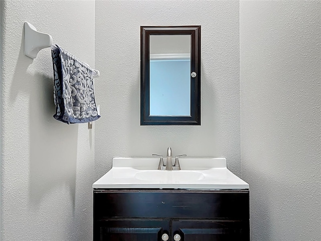 bathroom featuring vanity and a textured wall