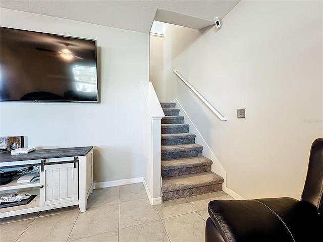 stairs featuring tile patterned floors and baseboards