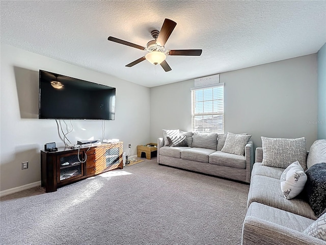 living room featuring carpet flooring, a textured ceiling, baseboards, and ceiling fan