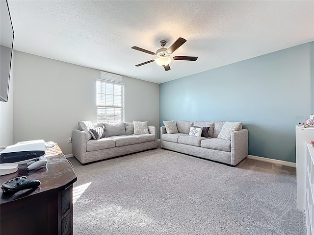 living room with a textured ceiling, carpet, baseboards, and ceiling fan