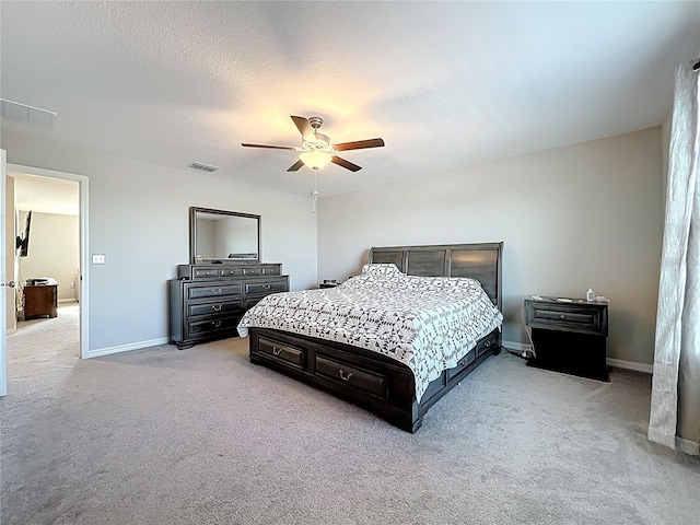 bedroom with a textured ceiling, ceiling fan, baseboards, and light carpet