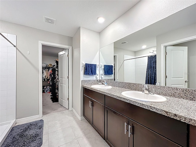 full bathroom with a walk in closet, a shower stall, visible vents, and a sink