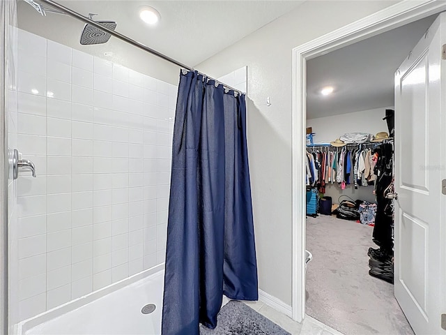 bathroom featuring a walk in closet and a stall shower