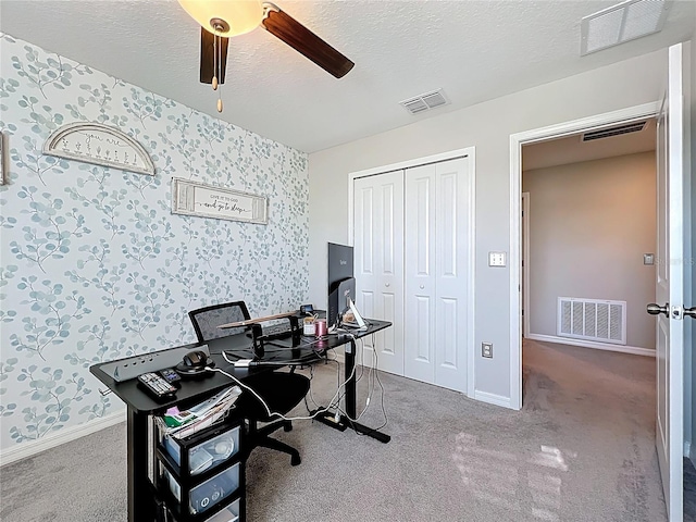 office featuring visible vents, a ceiling fan, and wallpapered walls