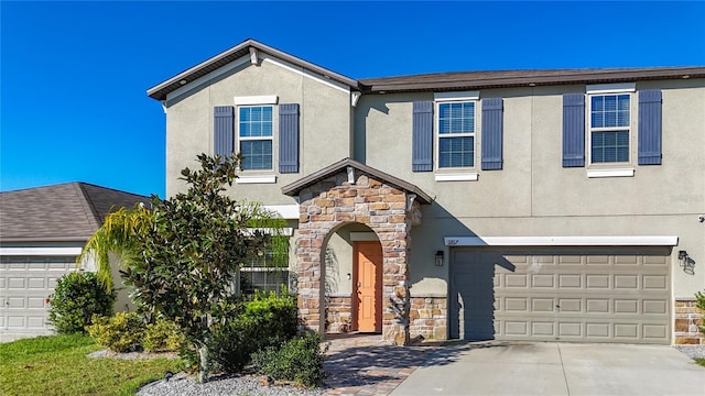 traditional home with concrete driveway, an attached garage, stone siding, and stucco siding