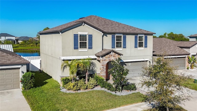 traditional-style home with stucco siding, stone siding, concrete driveway, and fence