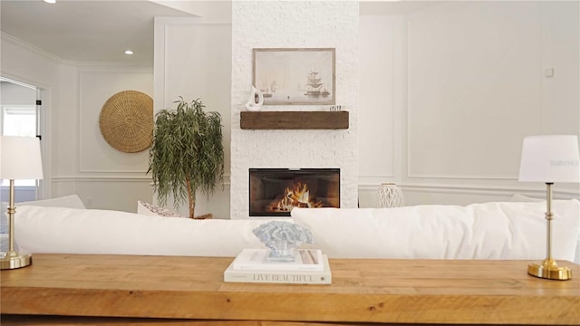 interior space with a decorative wall, a fireplace, and ornamental molding