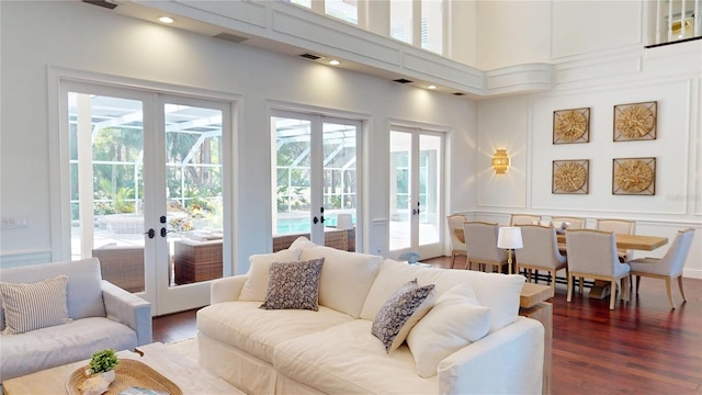 living area featuring a healthy amount of sunlight, french doors, and wood finished floors