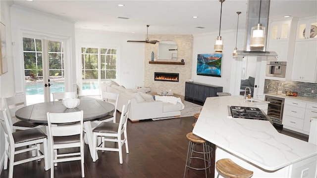 kitchen with beverage cooler, decorative backsplash, white cabinets, and ornamental molding