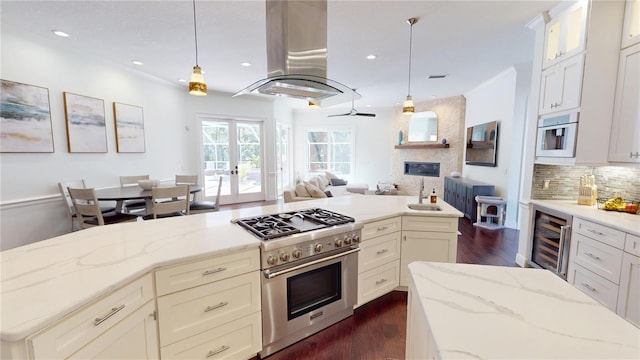 kitchen featuring high end range, beverage cooler, open floor plan, tasteful backsplash, and island range hood