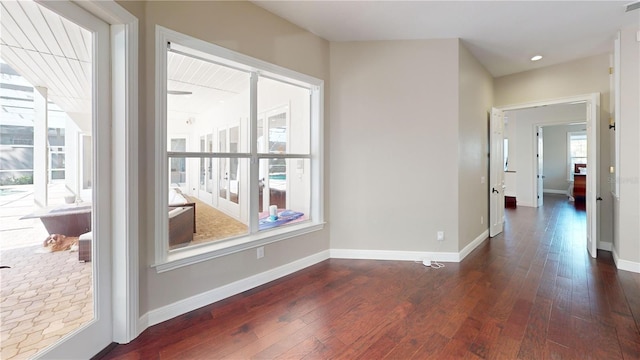 interior space with plenty of natural light, baseboards, and dark wood-style flooring