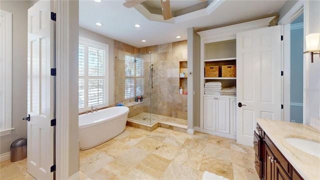 bathroom with ceiling fan, recessed lighting, a stall shower, a freestanding tub, and vanity