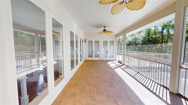 unfurnished sunroom featuring ceiling fan