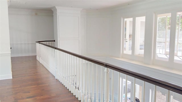 hallway featuring crown molding, wood finished floors, and baseboards