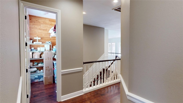 hallway featuring wood finished floors, an upstairs landing, and baseboards