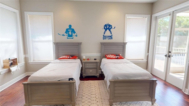 bedroom featuring access to exterior, wood finished floors, and baseboards